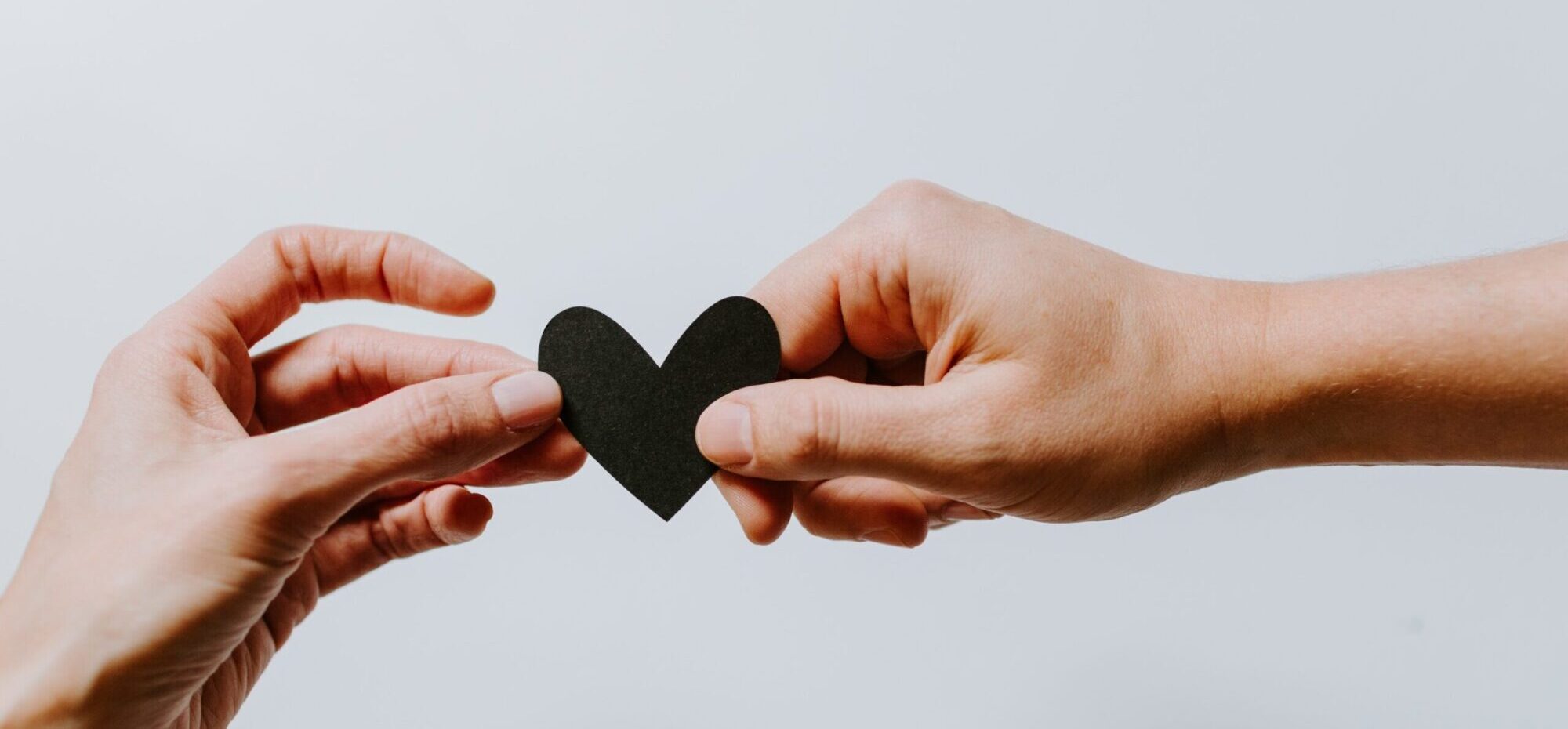 Two hands holding a paper heart